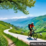 코소보에서 자전거 타기 좋은 곳 - A scenic mountain cycling trail in Kosovo during spring, featuring lush green hills and colorful wil...